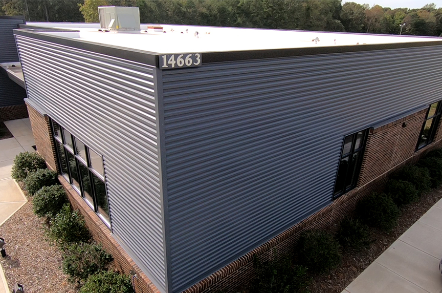 (article) What Are Metal Wall Panels? Benefits, Uses, and Types gray wave metal wall panels on commercial building