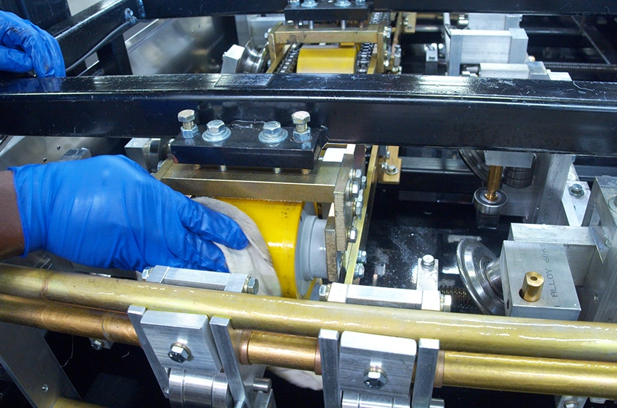wiping down yellow drive rollers with rag