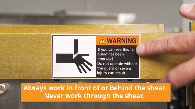 Shear warning label. Always work in front of or behind the shear. Never work through the shear.