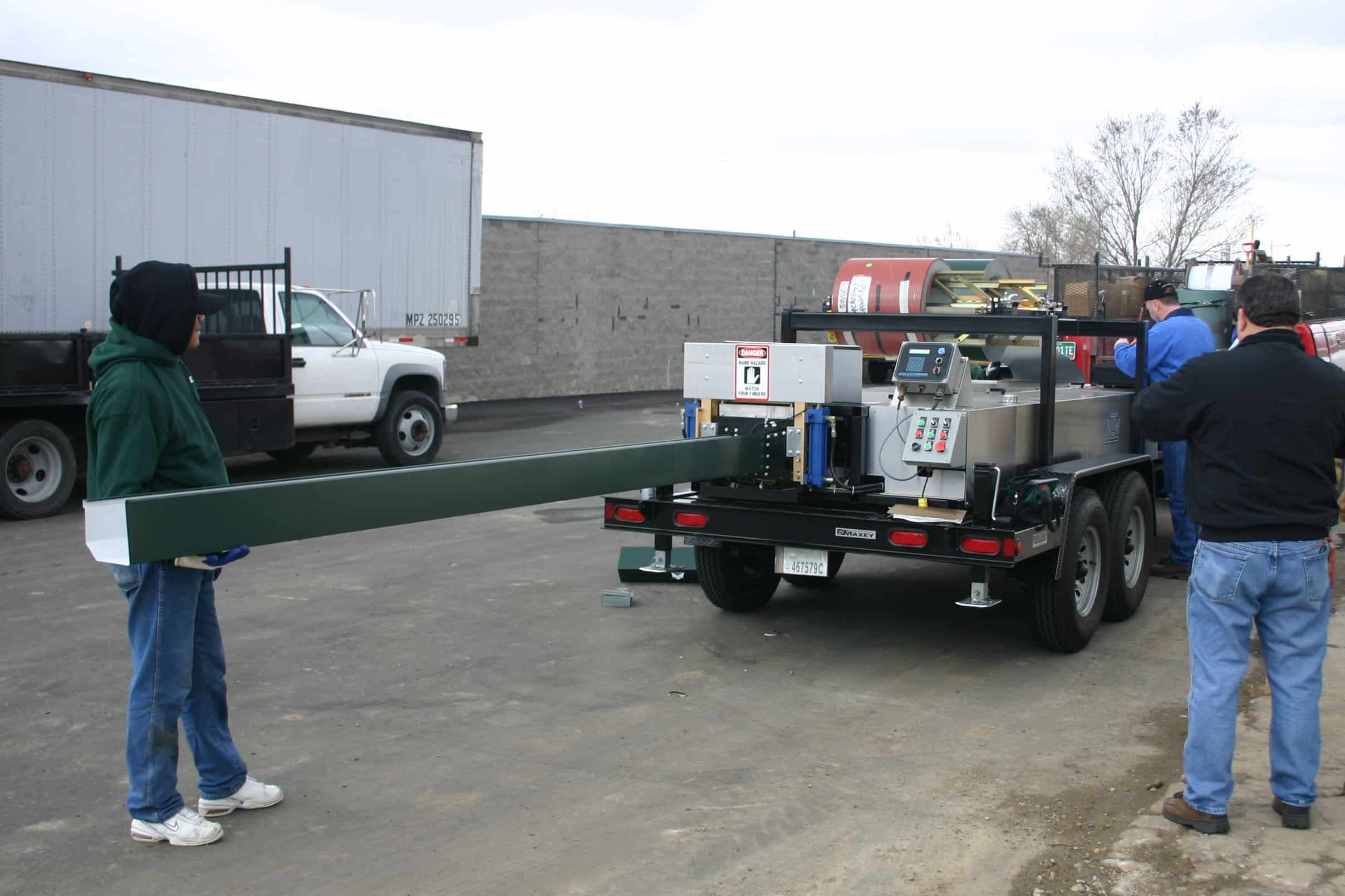 workers running a gutter machine.