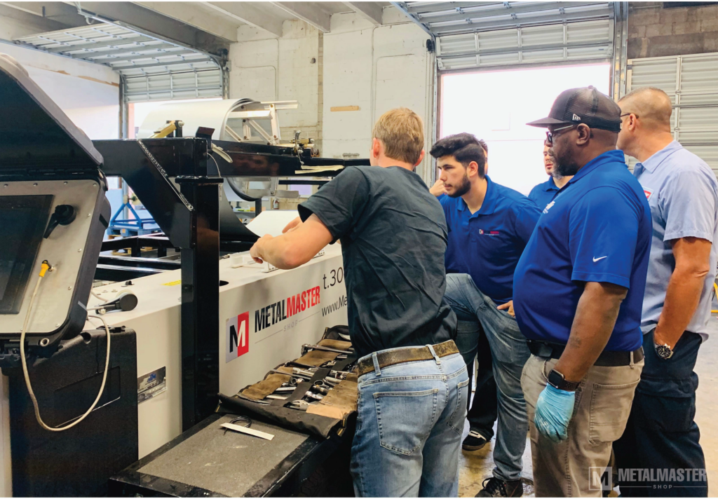Service members helping customers adjust a rollforming machine.