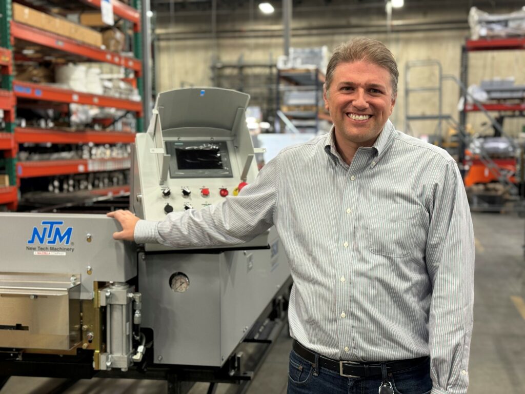 Man next to an NTM portable rollformer.