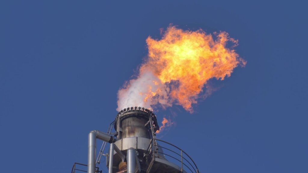Smokestack emitting flames at an oil refinery.