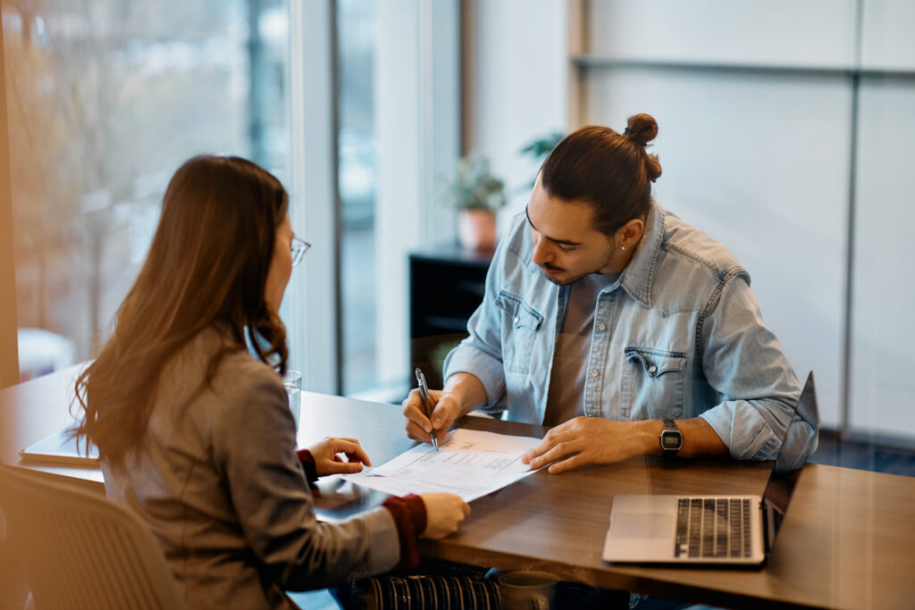 A man at a bank signing for a loan.