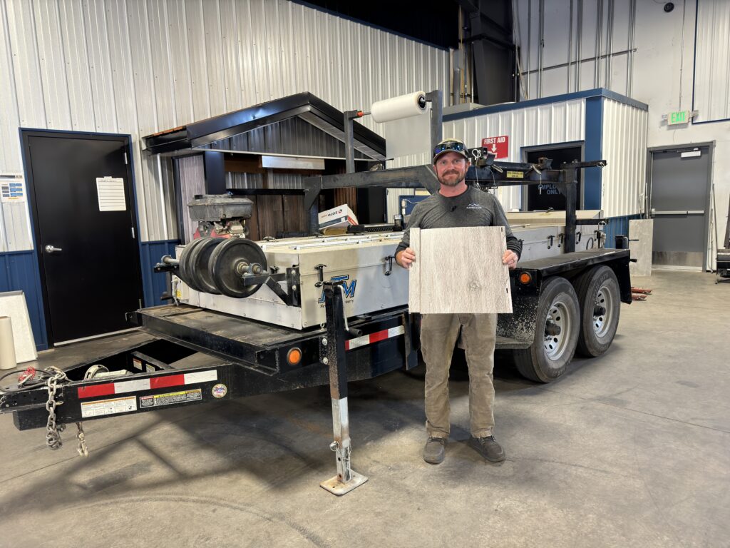 Lee smith holding a panel in front of an SSQ II machine.