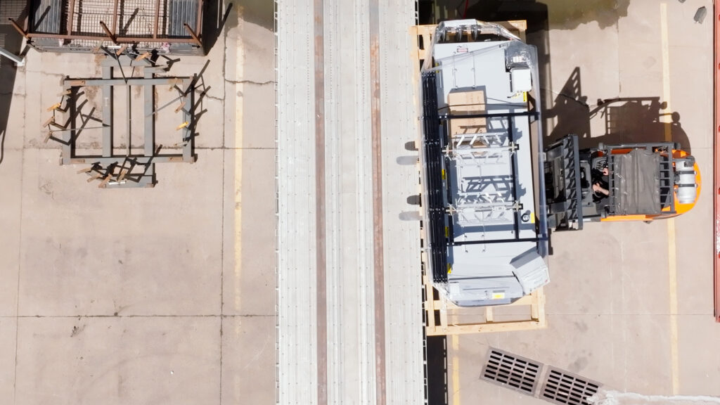 Offloading a machine from the side of a truck.