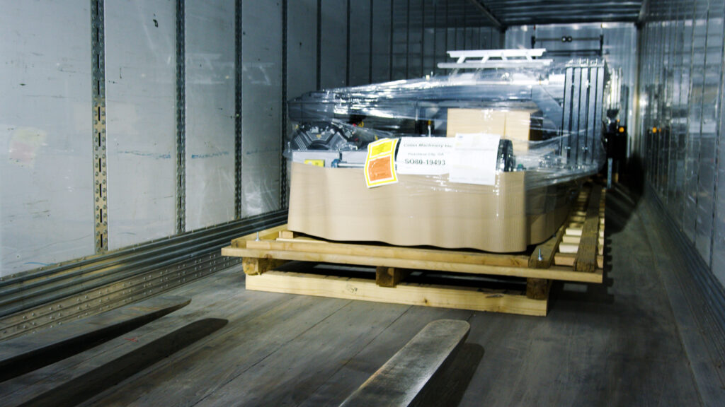 Unloading machine on a skid using forklift.
