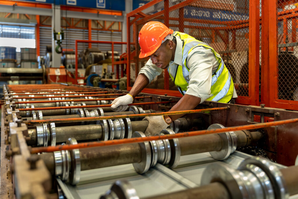 Operator checking the rollers on an in-plant rollforming machine.