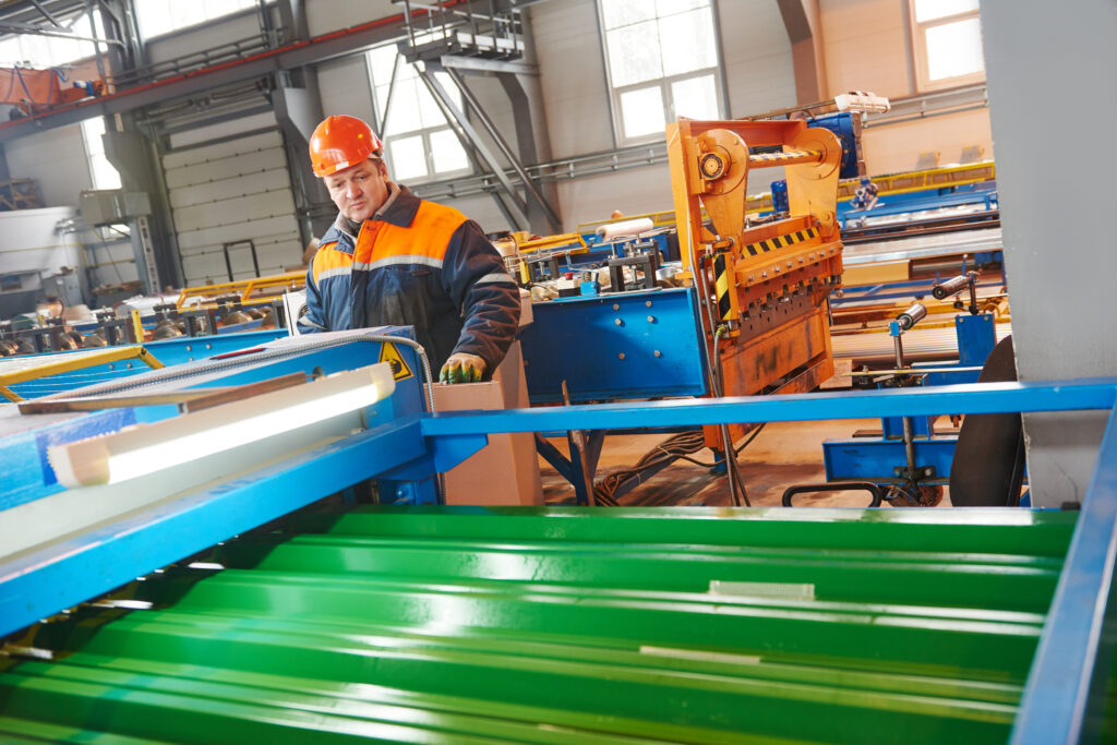 industrial worker operating in-plant rollforming machine